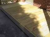 Decking built for kitchen exterior covered porch entrance made of pressure treated lumber at home on University Boulevard, Silver Spring, MD.